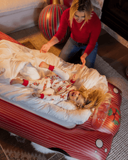 Woman in a red sweater interacting with a child on a large inflatable slide.